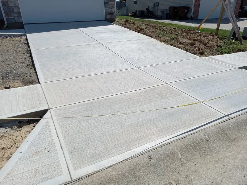 Newly poured concrete driveway with professional broom finish. Newly poured concrete driveway with professional broom finish.