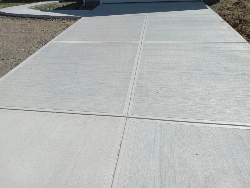 Clean concrete driveway with fresh broom finish and joints. Clean concrete driveway with fresh broom finish and joints.