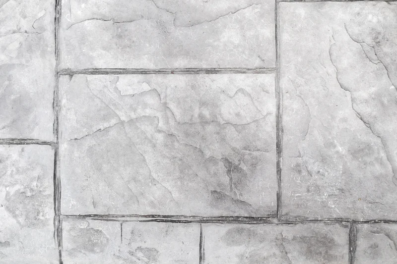 Stamped concrete texture mimicking light gray natural stone tiles. Stamped concrete texture mimicking light gray natural stone tiles.
