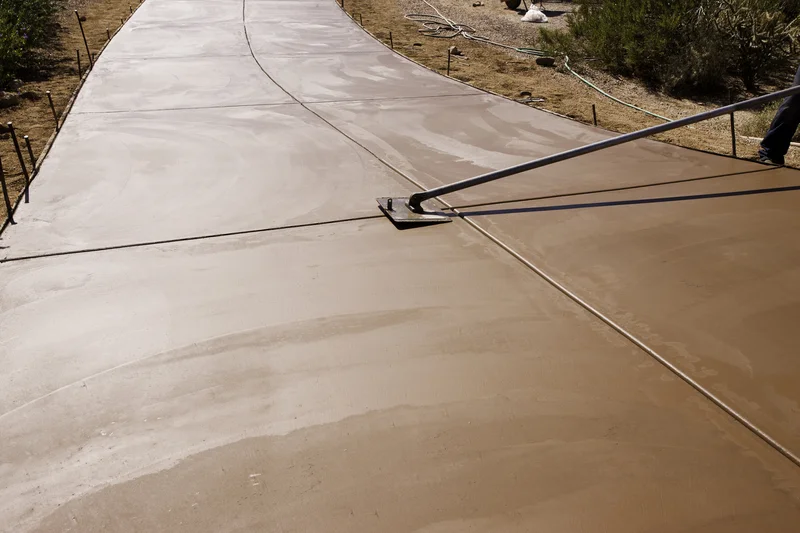 Concrete contractor cutting expansion joints on a new driveway. Concrete contractor cutting expansion joints on a new driveway.